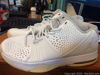 Side profile of the white Nike Air Jordan basketball shoes showing perforated upper and Jumpman logo.