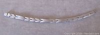 The bracelet laid out flat on a light surface showing the entire length and design of the links.