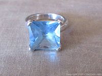 Front view of vintage sterling silver ring featuring a square faceted blue glass stone approximately 0.5 x 0.5 inches in size. Ring band is substantial and marked 925 indicating sterling silver.