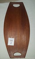 Full front view of the teak surfboard tray showing shape and integrated handles.
