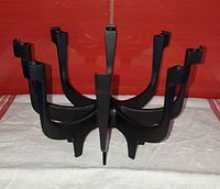 Front side view of black cast zinc candle holder showing all eight arms and candle holders.