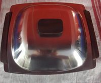 Top view of mid-century stainless steel serving bowl with teak wood handles and lid knob