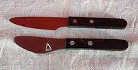Photo showing the top view of both knives with blades fully visible, highlighting different blade shapes and handle design.