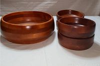 Five wooden salad bowls: one large multi-tone wood finish bowl and four smaller dark stained bowls in two size variations