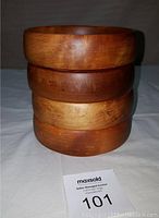 Four wooden bowls stacked on top of each other showing natural wood finish and thickness