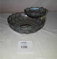 Photo of large and small iridescent carnival glass bowls with metal bracket, showing textured honeycomb pattern and overall condition.