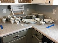 Complete Noritake Rosamor china set arranged on kitchen counter with all pieces visible and grouped by type