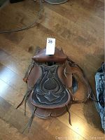 Top-down view of child's saddle showing decorative stitching on seat and horn.