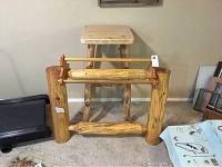 Front view of rustic blanket rack and lodge pine table showing natural log construction and decorative tree detail.
