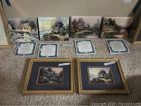 Full view of the four ceramic plates in a row with certificates of authenticity placed below and two framed artworks in front.