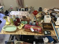 Full lot overview with assorted pottery vases, candleholders, cribbage boards, and a brass magnifying glass