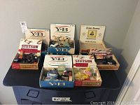 Wide view of 9 vintage cigar boxes filled with various antique and vintage toys including toy vehicles, army men, animals, and other small toys.