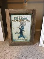 Front view of the cabinet showing the De Laval cream separators metal advertising sign framed in wood.