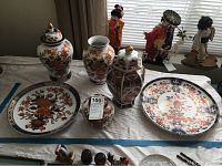 Front view of the 6 pieces showing the two large lidded urns, hexagonal ginger jar, round plates, and smaller ginger jar.