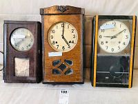 Main view of three vintage Japanese wooden wall clocks, arranged side by side showing front faces, woodcases, and glass fronts.