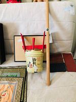 The full lot showing silk mats stacked, display bases behind, the Mt Fuji walking stick upright, and the sake bucket centered.