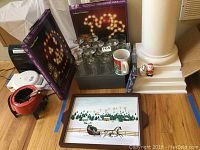 Photo showing holly wine glasses, dessert cups, Santa salt and pepper shakers, JOY mug, VHS tapes, and packaged pumpkin and ghost string lights.