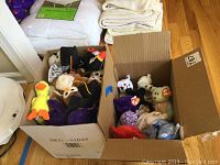 Two boxes filled with assorted Beanie Babies plush toys in various colors and shapes, some with attached TY tags.