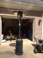 Full height view of the Bellezza outdoor heater showing the complete unit from base to top reflector, outdoor setting.