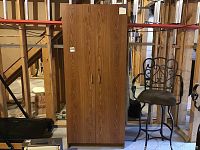 Front view of wooden storage cabinet with two vertical doors, natural woodgrain pattern, vertical handles.