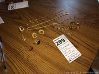 Group shot of chains, bracelets, rings, earrings, and anchor pendant on wood surface