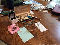 Three cuff bracelets and one ring arranged on tabletop next to lot tag