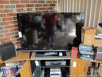 Front view of Toshiba television on stand with remote and lot tag visible