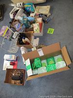 Photo showing multiple boxes and packs containing wipes, body wash, skincare items, and nail polish on a carpeted floor