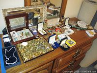 Dresser top with wooden watch box, small jewelry boxes, plastic tray, assorted necklaces, bracelets, earrings