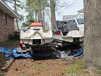 Rear view showing entire trailer frame with two jet skis loaded, single axle and tail lights.