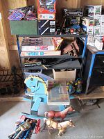 Wooden rocking horse, plastic figurines and metal horse figures on bottom shelf