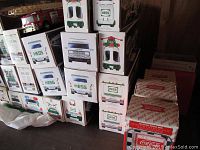 Wide view of stacked Hess vehicle boxes and stacked Coca-Cola music box packaging