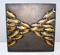 Front view of the salmon schooling metal fish wall art, showing two groups of stylized metal fish swimming toward each other on a square metal panel with a dark patina finish.