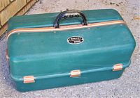 Closed exterior view of green vintage UMCO 1000 fishing tackle box showing handle and metal latches.