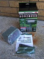 Photo of Bell & Howell Solar Animal Repeller packaging with the device, instruction manual, and stakes included.