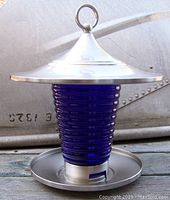Front view showing cobalt blue ribbed glass container with stainless steel top with hanging loop and base tray