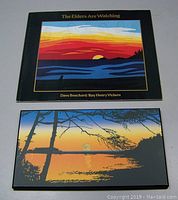 Photo showing the book and framed print together on a neutral surface.