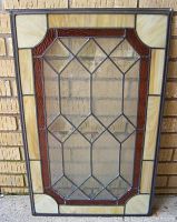 Front view of the leaded glass window insert showing the clear and amber glass with lead framing.