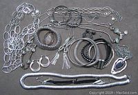 Full assortment of costume jewelry including various necklaces, bracelets, earrings, and bangles laid out on a neutral surface.