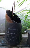Front angled view showing charcoal bucket embossed chuck wagon design and rust on handle.