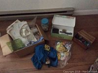 Overall view of boxes and bags containing drafting tools, buttons, belt buckles, safety vest, and papers.