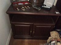 Front view showing two doors with brass handles and open shelf above