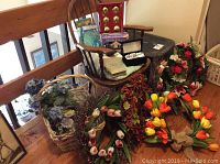 Full view of the vintage wooden rocker with assorted floral wreaths and holiday decorations around it.