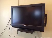 Front view of black Sanyo 31-inch flat screen TV mounted on wall with visible cable disconnected.