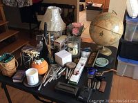Overview of multiple items on table showing globes, lamps, knives, and more