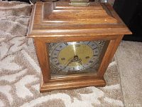 Front view of Ridgeway wooden mantel clock showing brass face with Roman numerals and decorative details.