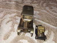 Front-facing photo of two vintage Bass diecast cars on a textured surface showing sizes and details.