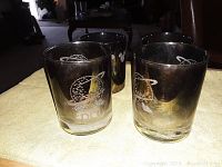 Side view of two clear glass tumblers with etched Mickey Mouse design