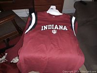 Maroon sleeveless Indiana University team shirt size medium folded on hanger, showing front with 'INDIANA' and IU logo