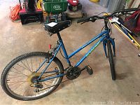 Full side view of the blue Schwinn Hurricane hybrid bicycle showing frame, tires, chain, gears, pedals, and handlebars